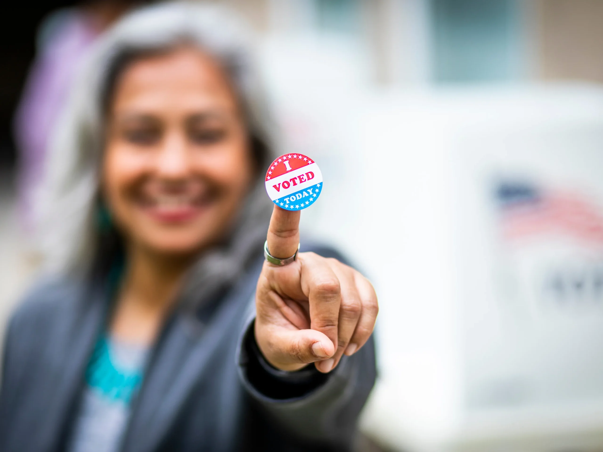 woman holding political advertising sticker and smiling